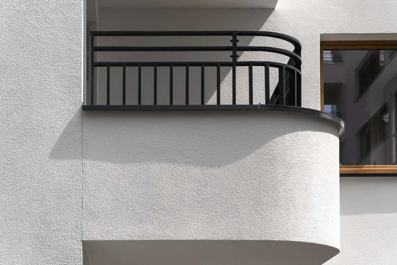 White curved EIFS balcony.