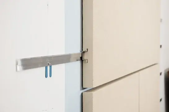 Close up of exterior wall panel being attached to building.
