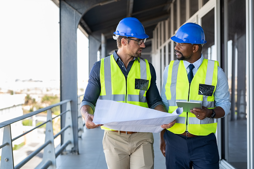 Two construction workers talking over a blueprint.